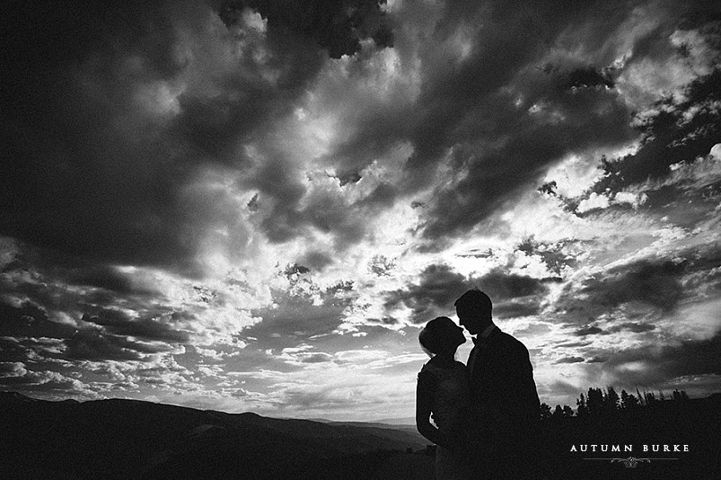 silhouette of bride and groom dramatic sky black and white